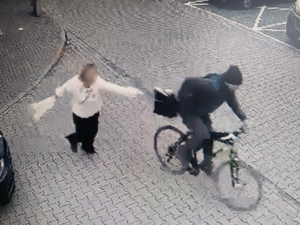 zdjęcie z monitoringu przedstawia mężczyznę na rowerze i idącą kobietę