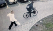 zdjęcie z monitoringu przedstawia mężczyznę na rowerze i idącą kobietę