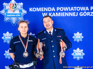 policjant i policjantka z medalami w dłoniach