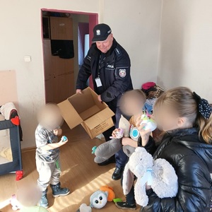 policjant daje dzieciom zabawki