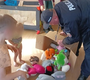 policjant przegląda zabawki z dzieckiem
