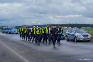 policjanci biegną wzdłuż lotniska