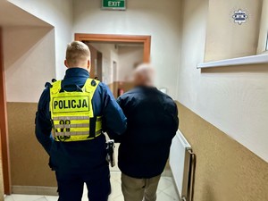 zatrzymany prowadzony przez korytarz przez policjanta