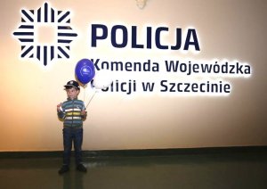 chłopiec na tle logo KWP w Szczecinie