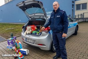 policjant i zabawki spakowane do radiowozu