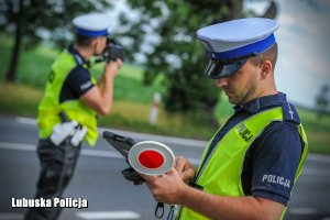 policjant kontroluje prędkość pojazdu, a drugi obsługuje tablet