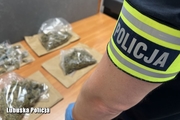 policjant stoi przy zabezpieczonych narkotykach