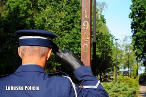 Policjant oddaje hołd przy Krzyżu Ofiar Katynia