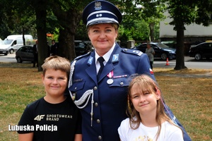 Policjantka pozuje z dziećmi do zdjęcia.
