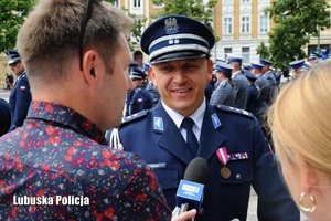 Policjant udziela wywiadu dziennikarzowi.
