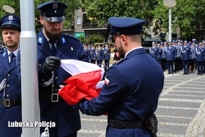 Poczet flagowy policjantów wciąga flagę na maszt.