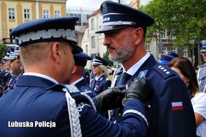 I Zastępca Komendanta Głównego Policji przypina odznaczenie policjantowi.