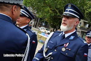 Policjant odbiera gratulacje od Komendanta Wojewódzkiego Policji.
