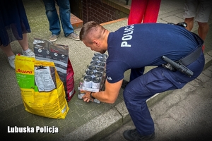 policjant przekazuje dary dla zwierzaków