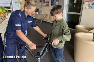 policjantka z chłopcem i jego rowerem