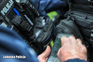 policjant sprawdza na telefonie mapę