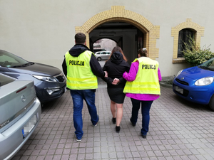policjanci prowadzą jedną z zatrzymanych kobiet
