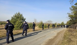 Policjanci w szeregu na polu.