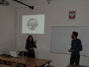 Podróżnicy Weronika Łukaszewska i Sławomir Sanocki podczas prelekcji, w tle prezentacja z wyprawy