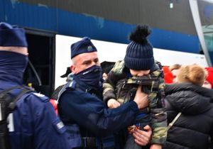 Policjant przenosi na rękach dziecko