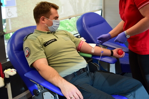 funkcjonariusz służby celno skarbowej siedzący na fotelu oddający krew