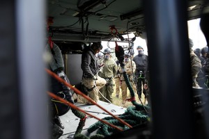 Zamaskowany kontrterrorysta mocuje liny w helikopterze