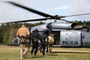 Policyjni zamaskowani kontrterroryści wbiegają do Black Hawka