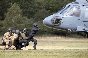 Lądujący helikopter i policjanci go przyjmujący