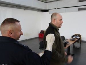 policjant ratownik zakłada opatrunek na amputowaną dłoń pozorantowi