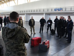 policjanci stoją w okręgu, w środku walizki do ćwiczeń