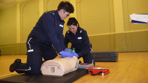 Recertyfikacja uprawnień z zakresu kwalifikowanej pierwszej pomocy - dwie policjantki na fantomie przeprowadzają resuscytację krążeniowo - oddechową