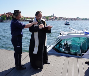 Ksiądz odmawia modlitwę tuż przed poświęceniem policyjnej łodzi