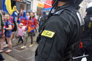 na zdjęciu umundurowani policjanci zabezpieczający przemarsz kibiców