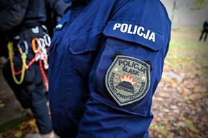 Zdjęcie. Ramię policjanta z naszywką z napisem policja śląska rozpoznanie minersko pirotechniczne