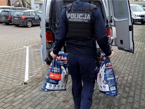 Policjanci przekazują karmę w schronisku