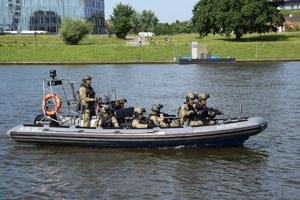 policyjni antyterroryści transportują łódką zabezpieczone pakunki