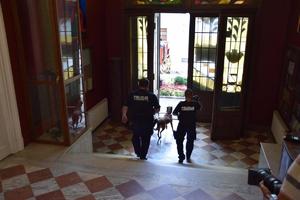 policjanci z psem tropiącym wychodzący z budynku