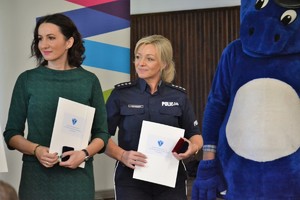 Członek Zarządu Województwa Małopolskiego Pani Marta Malec-Lech i policjantka ruchu drogowego odbierają dyplomy uznaniowe
