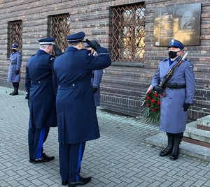 Komendant Wojewódzki Policji we Wrocławiu wraz z Naczelnikiem Wydziału Prezydialnego oddają honory przy tablicy patrona