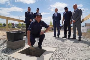 Komendant Powiatowy Policji w Polkowicach inspektor Waldemar Cichocki  symbolicznie wmurowuje tubę w fundament obiektu.