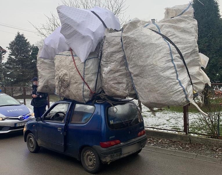 Samochód marki Fiat seicento na dachu znajduje sie ładunek