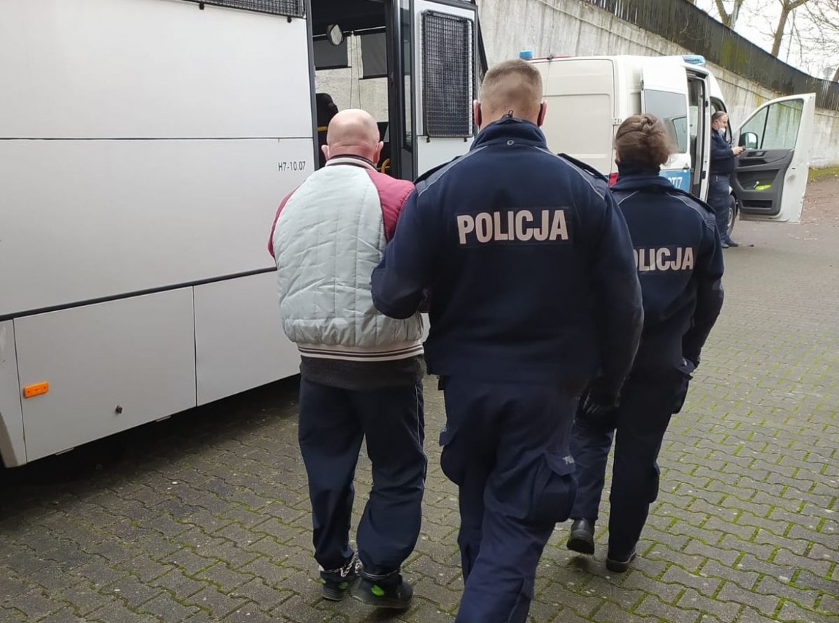 policjanci prowadzą zatrzymanego mężczyznę