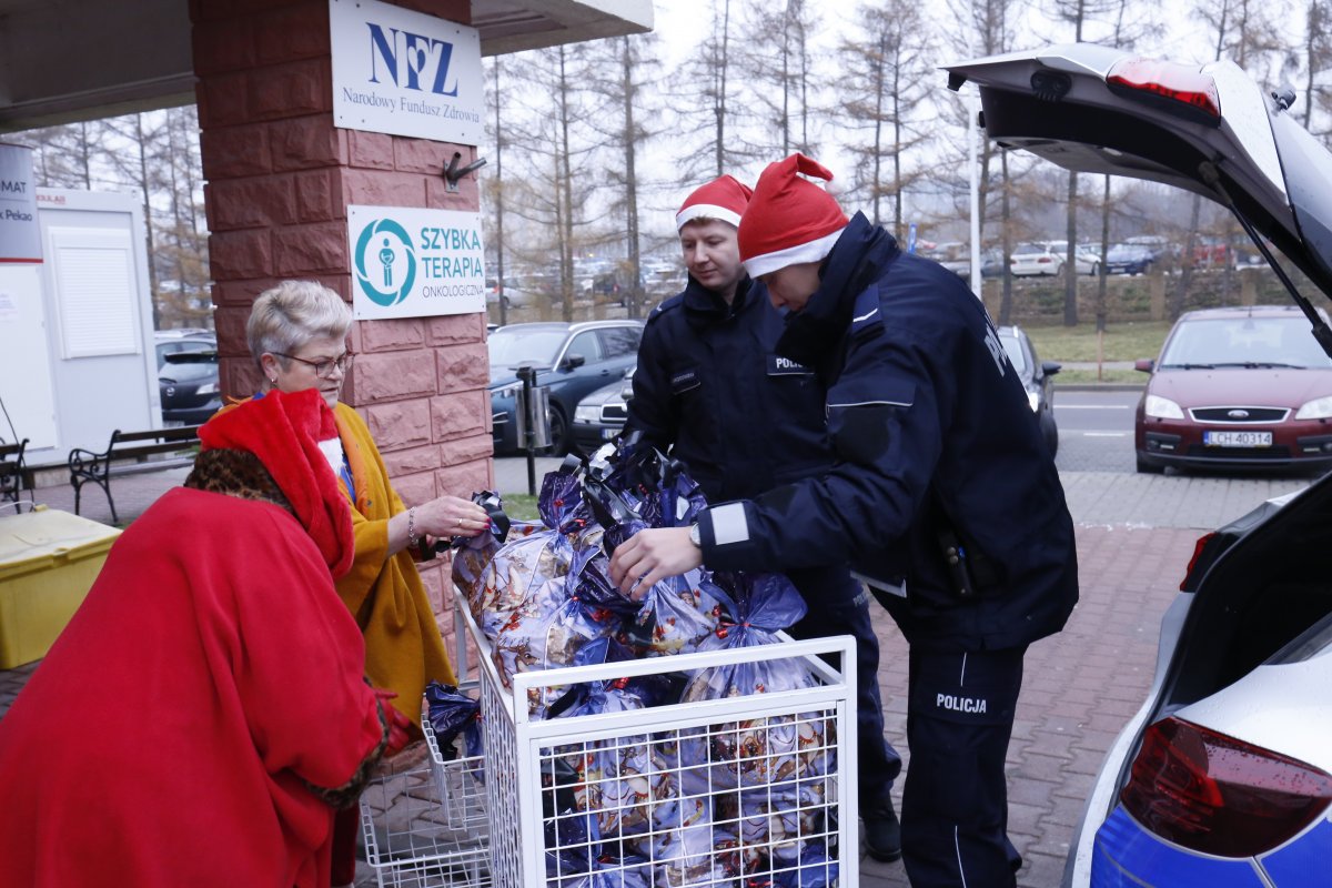 policjanci przekazują prezenty dla dzieci pracownikom szpitala