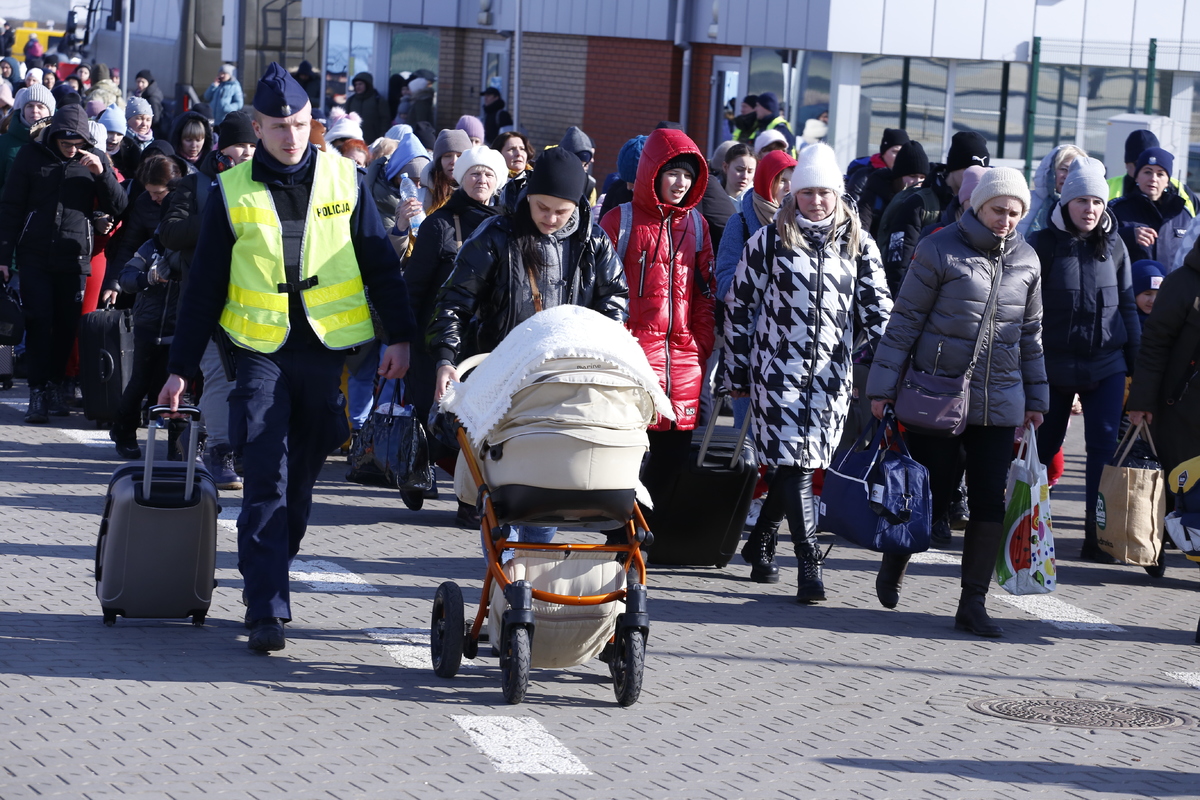 zdjęcie przedstawia kobiety i dzieci przekraczające granicę Polski