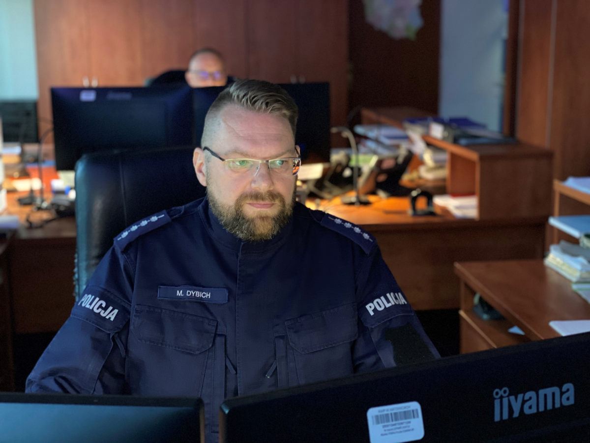 zastępca dyżurnego Komendy Miejskiej Policji w Jaworznie aspirant sztabowy Mariusz Dybich siedzi na swoim stanowisku przy komputerze