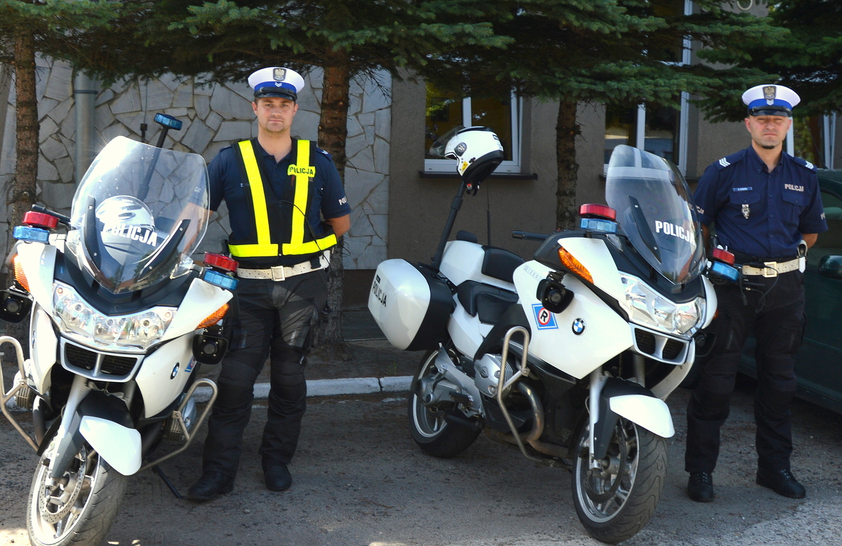 dwaj policjanci stoją przy motocyklach