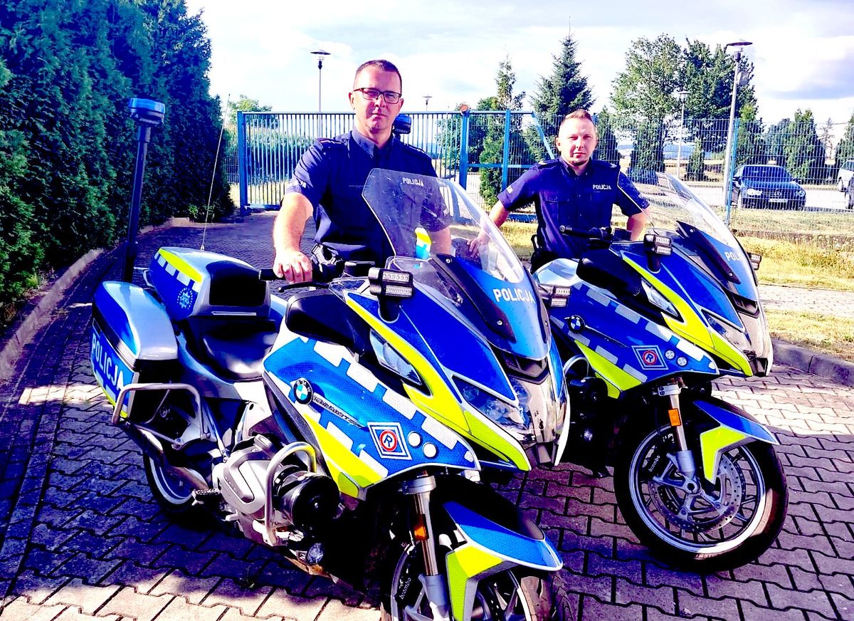 dwaj policjanci stoją przy policyjnych motocyklach
