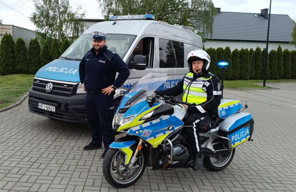 umundurowany policjant stoi przy policyjnym furgonie i funkcjonariusz na motocyklu