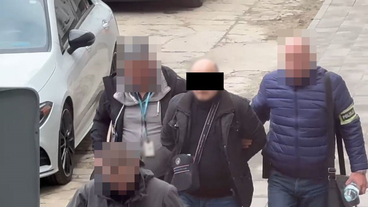 Policjanci prowadzą zatrzymanego.