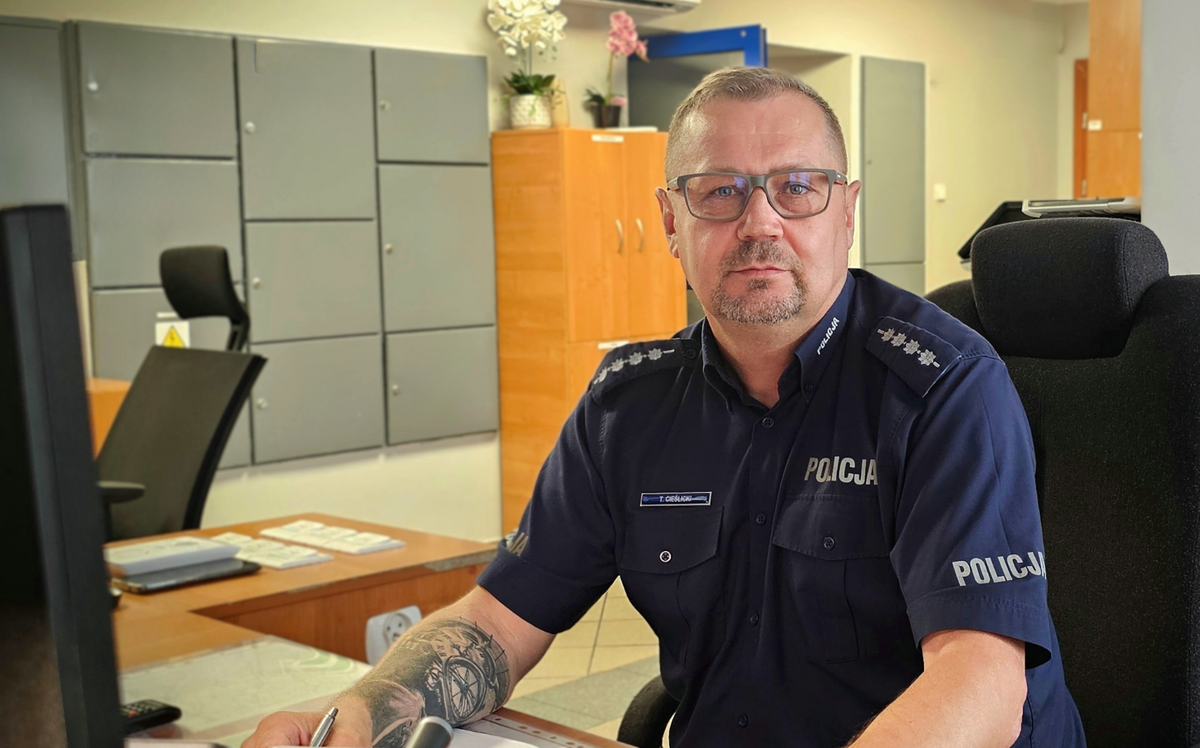 Asp. szt. Tomasz Cieślicki, dyżurny strzeleckiej komendy siedzi przy biurku.